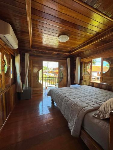 a bedroom with a large bed in a wooden room at Lamphu Resort Koh Lanta at Lanta Old Town in Ko Lanta