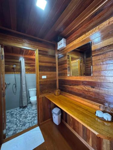 a wooden bathroom with a toilet and a mirror at Lamphu Resort Koh Lanta at Lanta Old Town in Ko Lanta