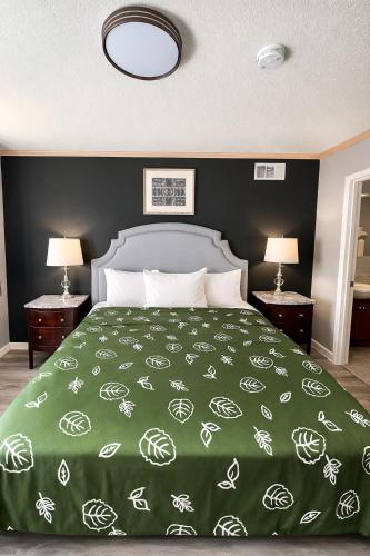 a bedroom with a large bed with a green blanket at Motel Edgebrook Chicago North Shore By Oyo in Chicago