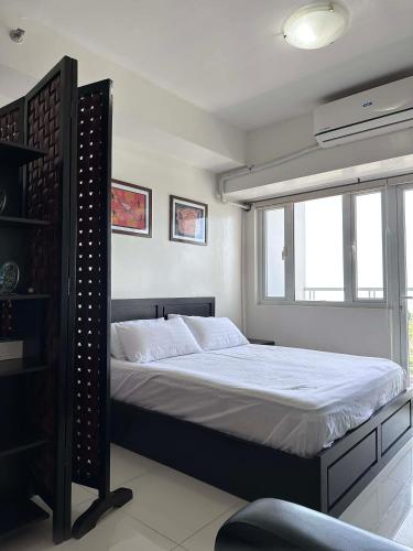 a bedroom with a bed and a window at SMDC Tagaytay Condominium in Kaybagal