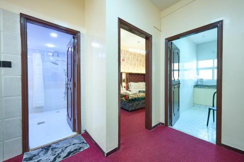 a bathroom with two doors and a walk in shower at Quality Hotel Apartments in Sabkhah