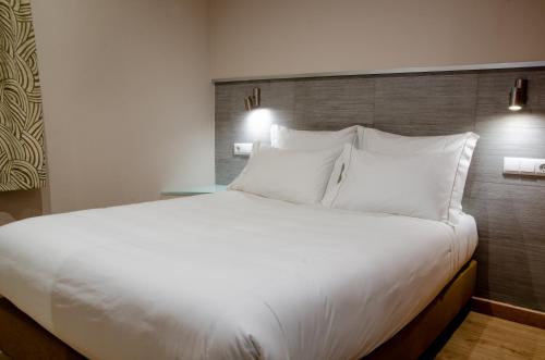 a large white bed in a hotel room at Hotel Bocage in Setúbal