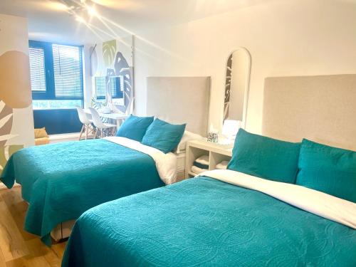a bedroom with two beds with blue and white sheets at Spacious 3BR City Centre Apartment Free Parking in Liverpool