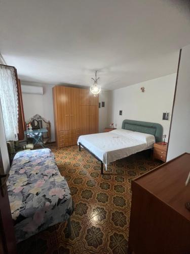 a bedroom with a bed and a couch in it at Intera casa con giardino, vista mare e montagna in Maratea
