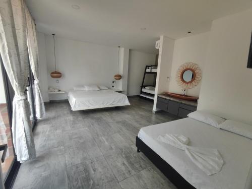 a bedroom with two beds and a mirror at Finca La Casa de Pablo in Doradal