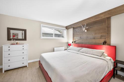 a bedroom with a large bed with a red headboard at Hameau 33-104 in Stoneham