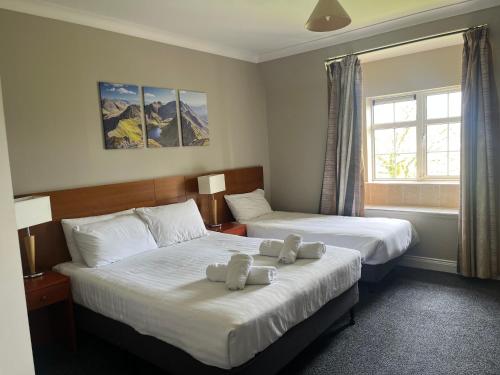 a hotel room with two beds with towels on them at River apartments, spacious 2 bedroom - muckross road killarney in Killarney