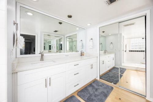 ein weißes Badezimmer mit zwei Waschbecken und Spiegeln in der Unterkunft Sol Vacation in Largo
