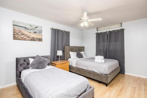 ein Schlafzimmer mit zwei Betten und einem Deckenventilator in der Unterkunft Sol Vacation in Largo