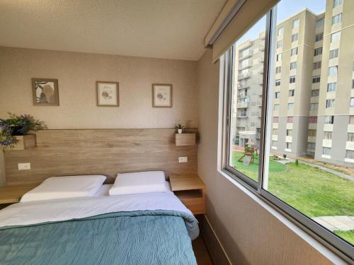 a bedroom with a bed and a large window at Acogedor Refugio en Tacna in Tacna
