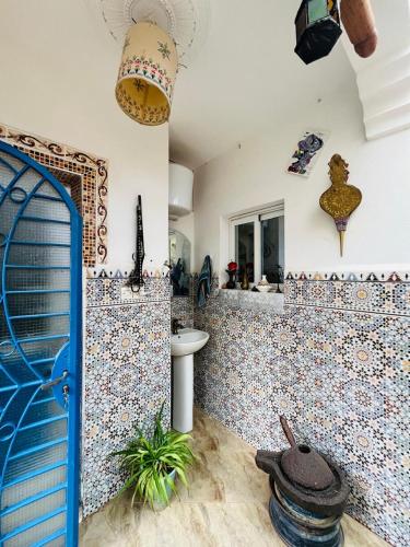 a bathroom with a blue door and a tile wall at Yamna home in Agadir