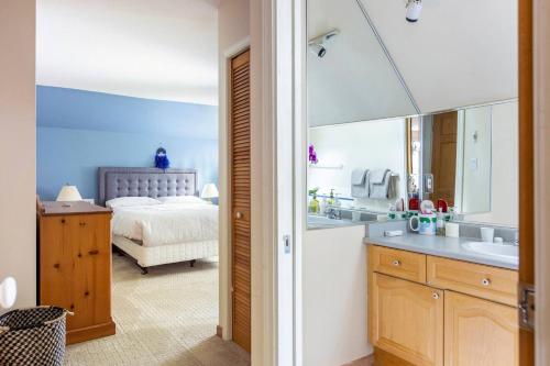a bathroom with a sink and a bedroom with a bed at 31GlenEagle Whistler in Whistler