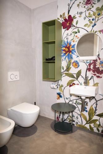 a bathroom with a toilet and a flower wallpaper at DEL CARMINE AGRIRESORT- ex a3passi in Ancona