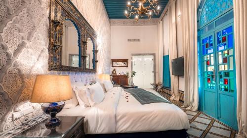 a bedroom with a large bed and a mirror at Riad Maison Bleue and Spa in Fez