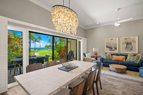 a dining room and living room with a table and chairs at Beachfront Lae Nani 3BD Condo AC & Heated Pool in Kapaa