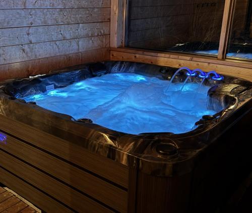 a jacuzzi tub in a house with blue water at Bukowiańska Ostoja Jacuzzi Sauna i Balia w Ofercie, 60m od Wyciągów in Bukowina Tatrzańska