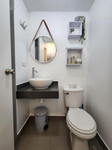 a bathroom with a sink and a toilet and a mirror at Acogedor Refugio en Tacna in Tacna