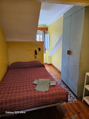 a bedroom with a bed with a red comforter at Pensao Residencial Flor dos Cavaleiros in Lisbon