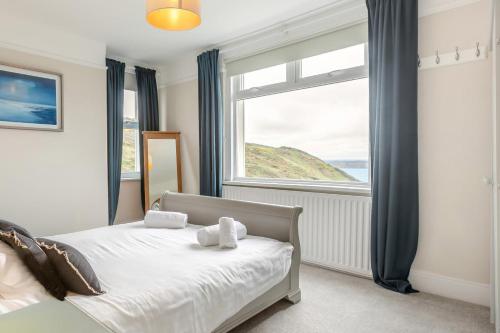 a bedroom with a bed and a large window at 6 Bed in Mortehoe oc-hillcr in Mortehoe