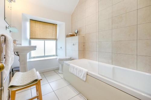 a bathroom with a tub and a toilet and a sink at 4 Bed in St. Mawgan oc-p00610 in Saint Mawgan