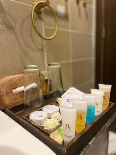 ein Tablett mit Toilettenartikeln auf einer Ablage im Badezimmer in der Unterkunft Brava Hotel in Ibadan