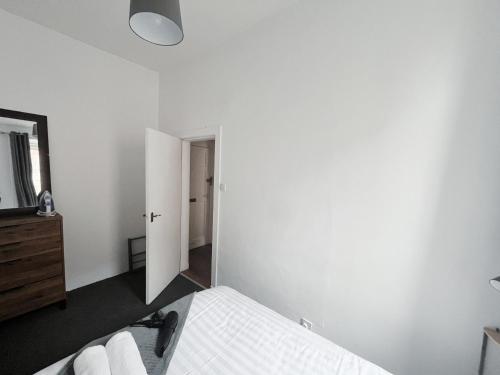 a white bedroom with a bed and a mirror at Edinburgh Cozy Apartment in Edinburgh