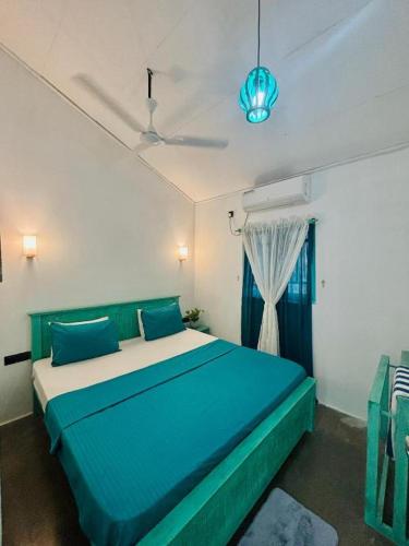 a bedroom with a blue bed in a room at Casa Meraki in Dickwella