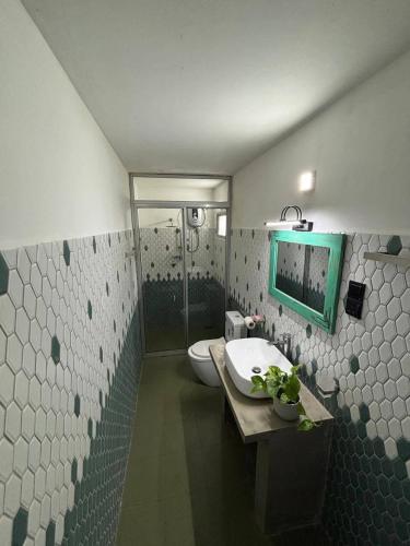 a bathroom with a sink and a toilet and a mirror at Casa Meraki in Dickwella