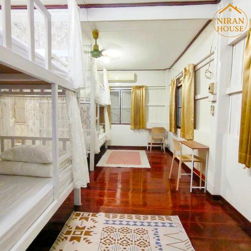 a bedroom with a bunk bed and a desk at NiranHouse Hostel in Sathani Phitsanulok