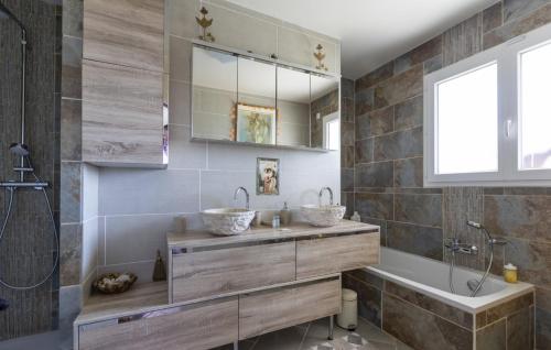 a bathroom with two sinks and a tub and a mirror at La Clef Des Anges 2 Chambres in Égliseneuve-près-Billom