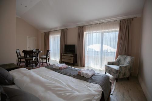 a bedroom with a bed and a table and chairs at By Tau in Almaty