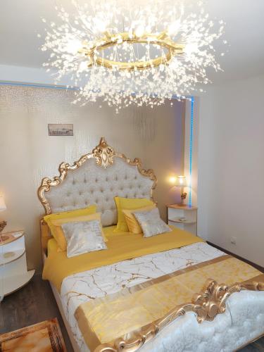 a bedroom with a large bed with a chandelier at La Clef Des Anges 2 Chambres in Égliseneuve-près-Billom