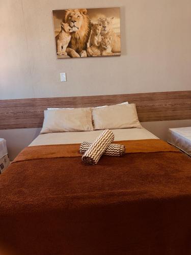 a bedroom with a bed with a picture of lions at Pousada O Leão in Piaçabuçu