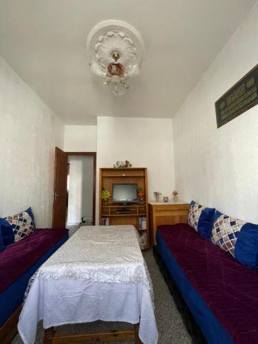 a bedroom with two beds and a television in it at Appartement Belle vue 3 Meknès in Meknès