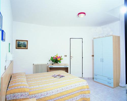 ein weißes Schlafzimmer mit Bett und Spiegel in der Unterkunft Hotel Acquazzurra in Rimini