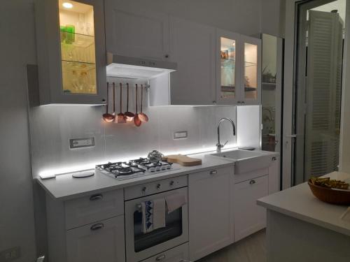 a kitchen with white cabinets and a stove top oven at Marè Sunrise in Bari