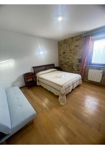 a bedroom with a bed and a wooden floor at Corrubedo Beach Lodge in Corrubedo