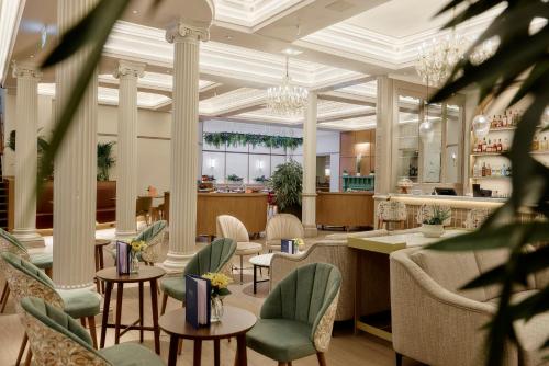 a restaurant with tables and chairs and a lobby at The Grand Hotel Leicester by The Unlimited Collection in Leicester