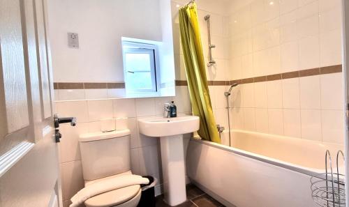 a bathroom with a toilet and a sink and a tub at Spacious 4 Bedroom House, Old Town in Swindon