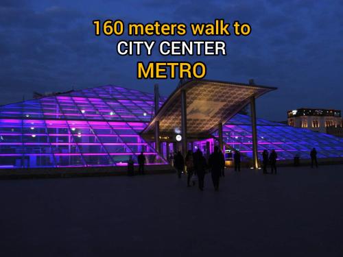 a group of people walking in front of a city center at night at KING City Center Hostel in Baku