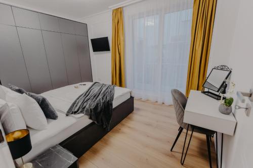 a bedroom with a bed and a desk with a laptop at Lumea Noir - Designer Apartment in Timișoara in Timişoara