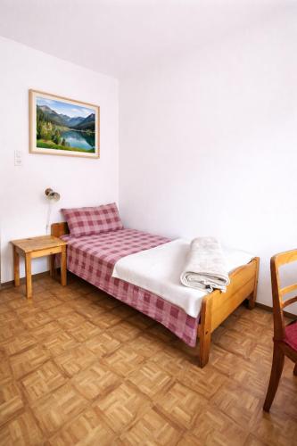 a bedroom with a bed and a table and a chair at Casa Arcobaleno in Airolo