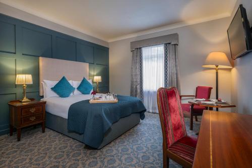 a hotel room with a bed and a desk and chair at Abbey Hotel Roscommon in Roscommon