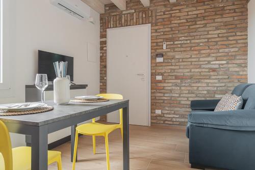 a dining room with a table and yellow chairs at LaVero Maison in Castelfranco Emilia