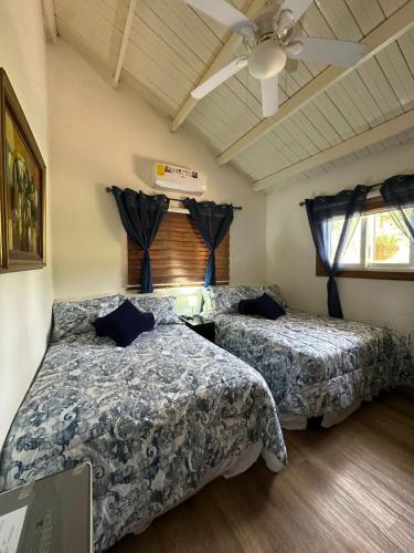 a bedroom with two beds and a ceiling fan at Casa Selva Escondida in Los Altos de Cerro Azul