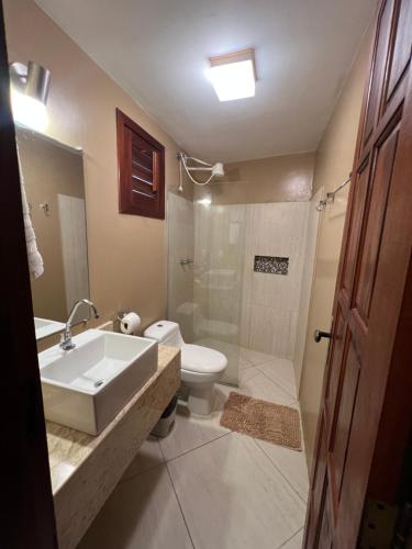 a bathroom with a sink and a toilet and a shower at Pousada Aruana in Canoa Quebrada