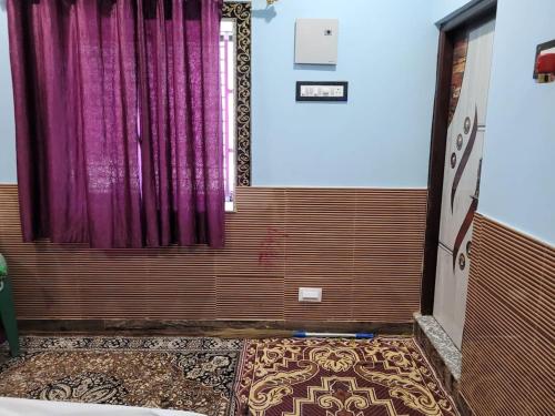a room with a purple curtain and a rug at The Fortune Mango in Jajpur Road