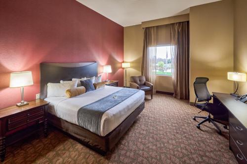 a hotel room with a large bed and a desk at Choctaw Casino & Resort Pocola, Trademark Coll by Wyndham in Pocola