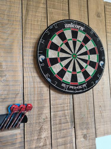 a dart board on a wooden table with darts at Chambre, comme au cinéma in Givet