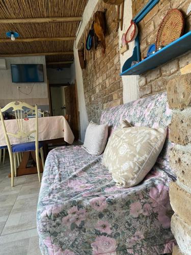a bed in a room with a brick wall at Casa Pili in San Vito